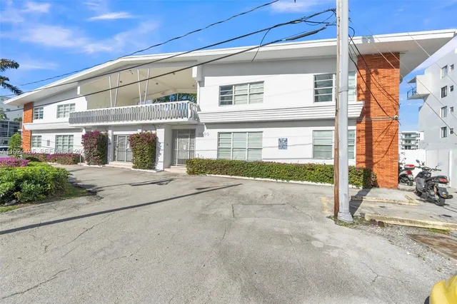 a front view of a building with a garden and plants