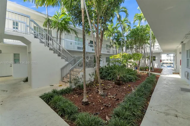 a view of a house with a yard and potted plants