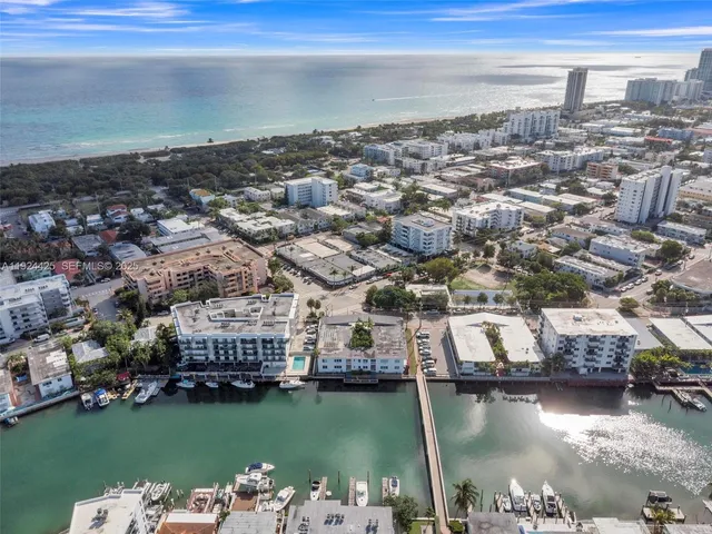 an aerial view of a city with lots of residential buildings ocean and mountain view in back