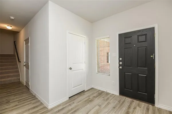 a view of kitchen with stainless steel appliances wooden floor and living room view