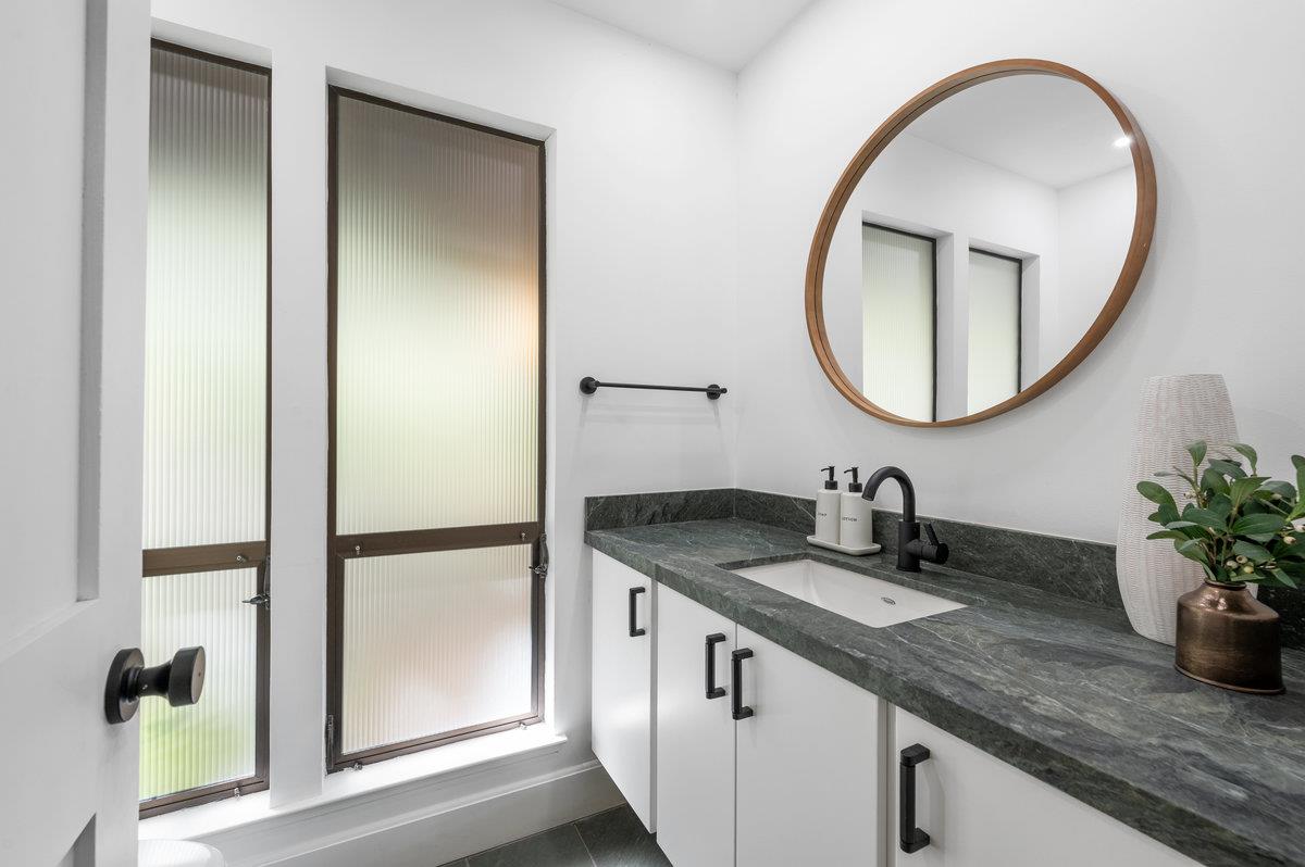 27 Oakwood Road Orinda, CA 94563 - Photo 25 of 61 a bathroom with a granite countertop sink and a mirror