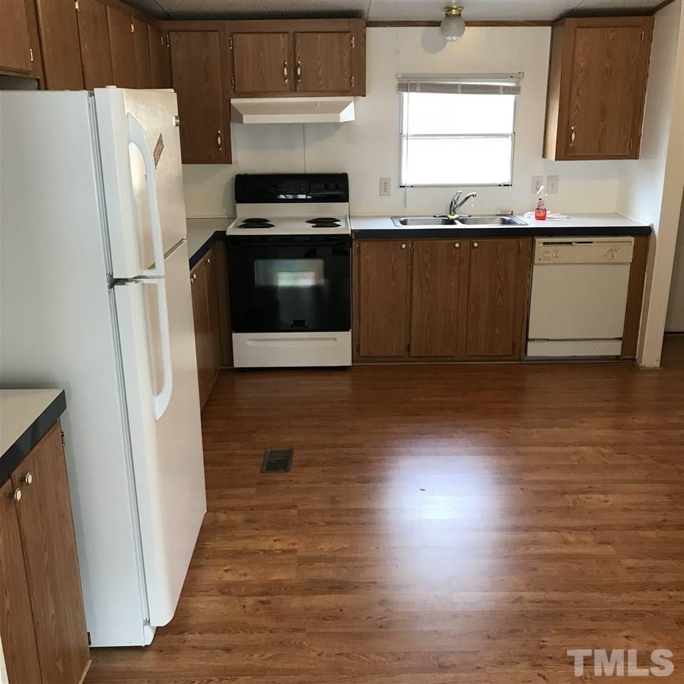 573 George Sherman Road Rougemont, NC 27572 - Photo 5 of 7 a kitchen with granite countertop a refrigerator sink and wooden floor