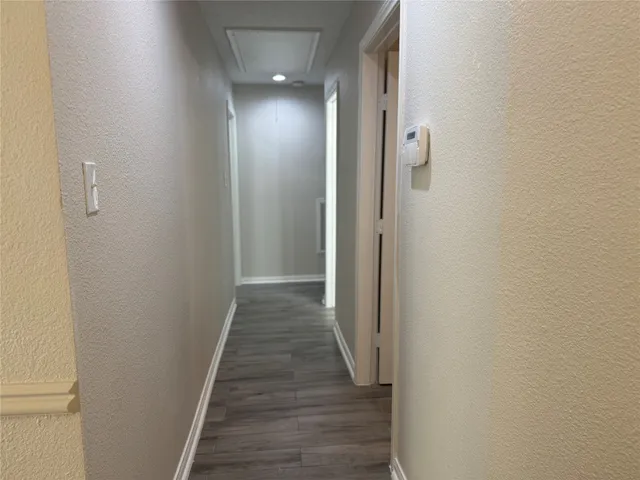 a view of a hallway with wooden floor