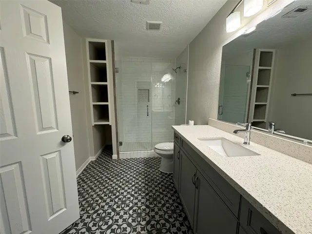 a bathroom with a double vanity sink toilet and shower