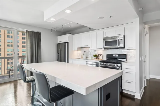 a room with a table chairs and a refrigerator