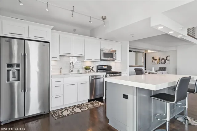 a kitchen with stainless steel appliances a stove a sink and a microwave