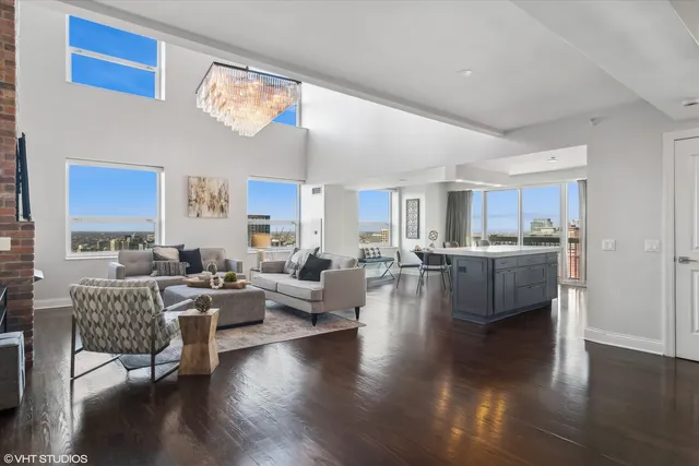 a living room with couches a coffee table and a large window with wooden floor