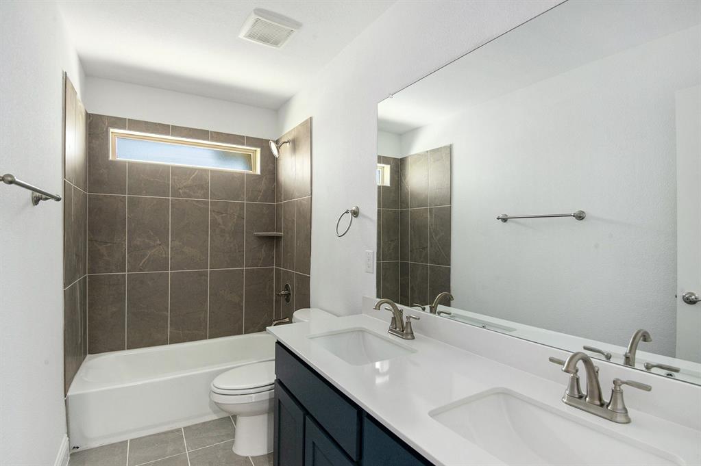 6033 Mango Drive Sanger, TX 76266 - Photo 24 of 29 a bathroom with a sink a toilet and shower