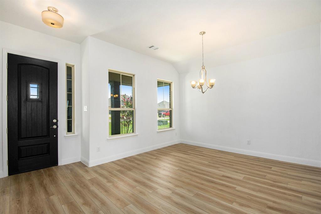 6033 Mango Drive Sanger, TX 76266 - Photo 4 of 29 an empty room with wooden floor cabinet and windows