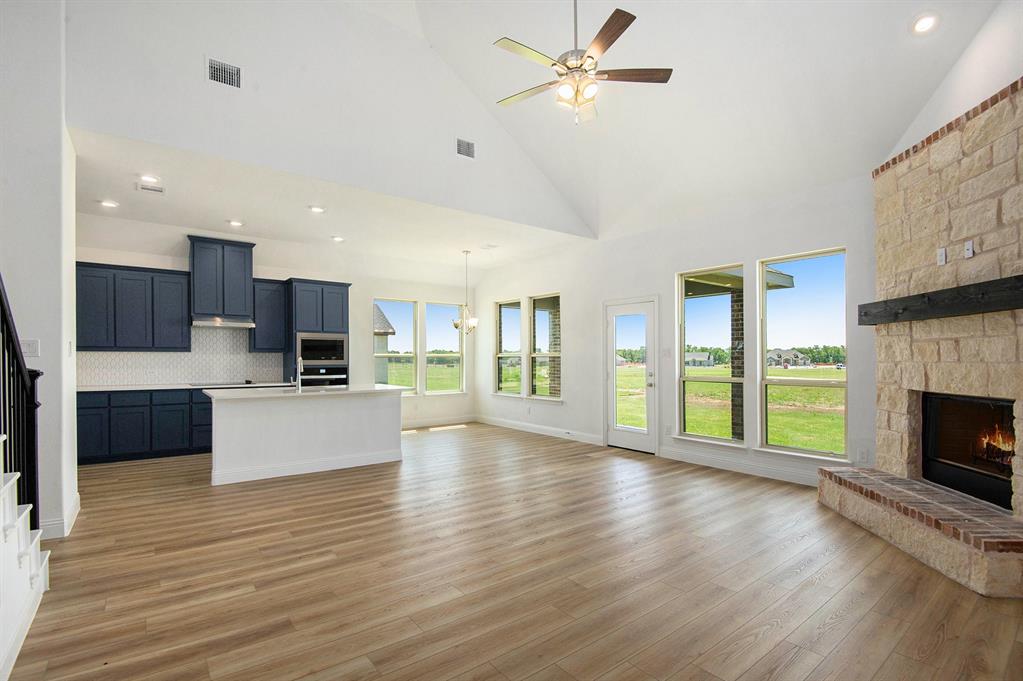 6033 Mango Drive Sanger, TX 76266 - Photo 9 of 29 a view of a kitchen with furniture a ceiling fan and wooden floor
