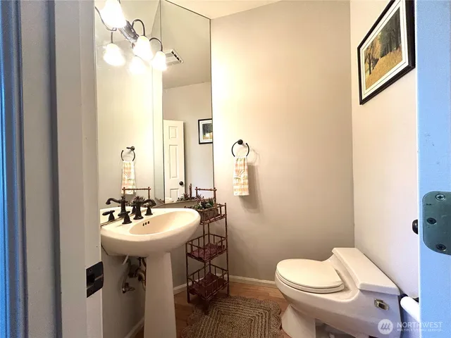 a bathroom with a toilet a sink and mirror