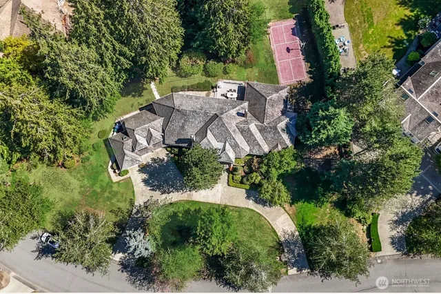 an aerial view of residential house with outdoor space and trees all around