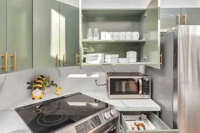 a kitchen with stainless steel appliances a table chairs in it and view living room