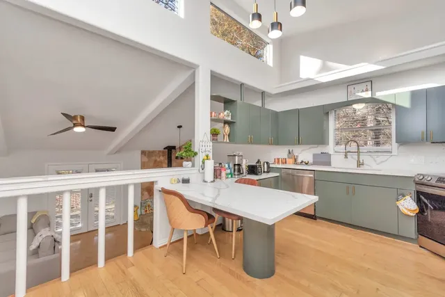 a living room with stainless steel appliances kitchen island granite countertop furniture and a couch