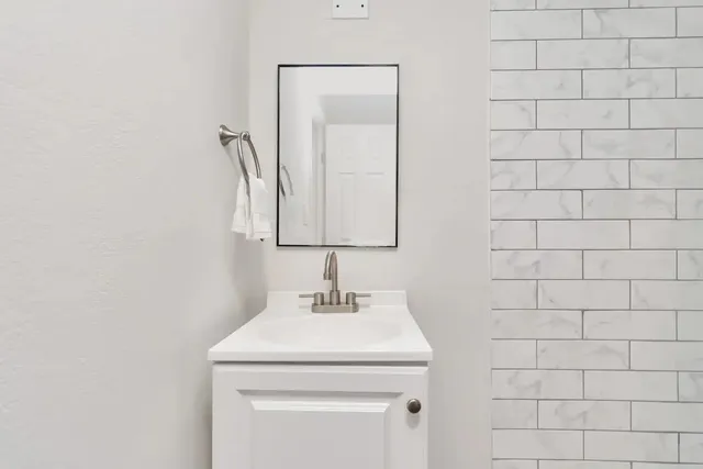 a bathroom with a shower sink vanity and toilet