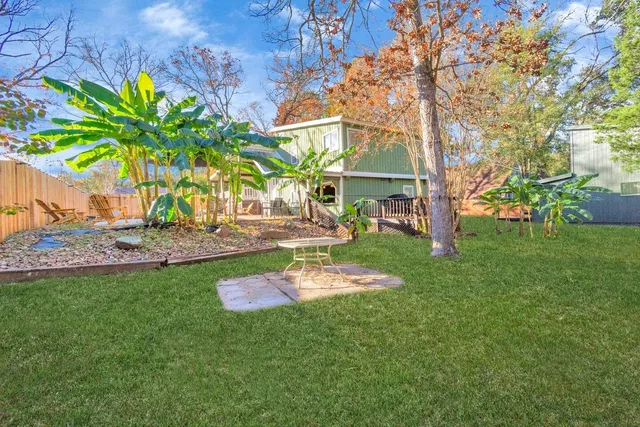 a backyard of a house with lots of green space and fountain