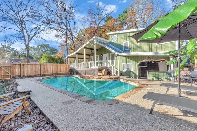 a view of a backyard with large tree and wooden fence