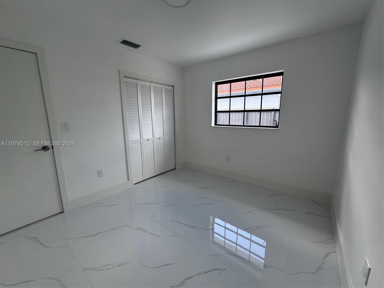 2682 West 70th Place Hialeah, FL 33016 - Photo 11 of 16 an empty room with windows