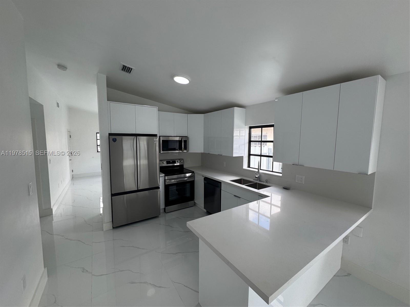 2682 West 70th Place Hialeah, FL 33016 - Photo 3 of 16 a kitchen with stainless steel appliances a refrigerator sink and stove