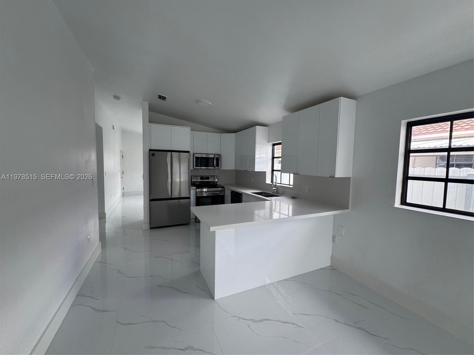 2682 West 70th Place Hialeah, FL 33016 - Photo 4 of 16 a large white kitchen with stainless steel appliances