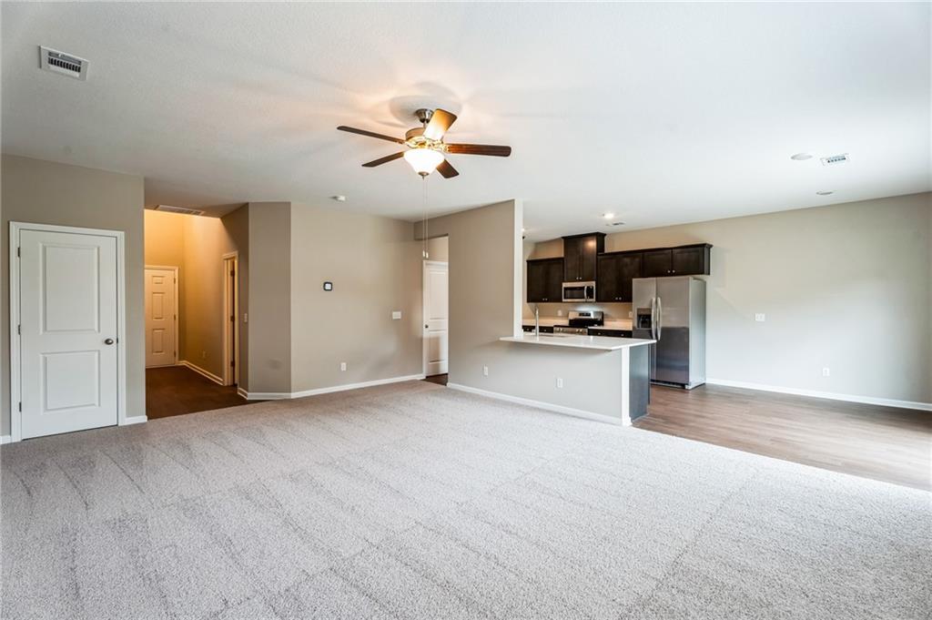 23 Whiterock Road Phenix City, AL 36869 - Photo 8 of 29 Unfurnished living room with carpet, visible vents, baseboards, and ceiling fan