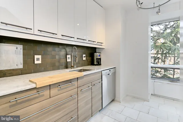 a kitchen with white cabinets and appliances