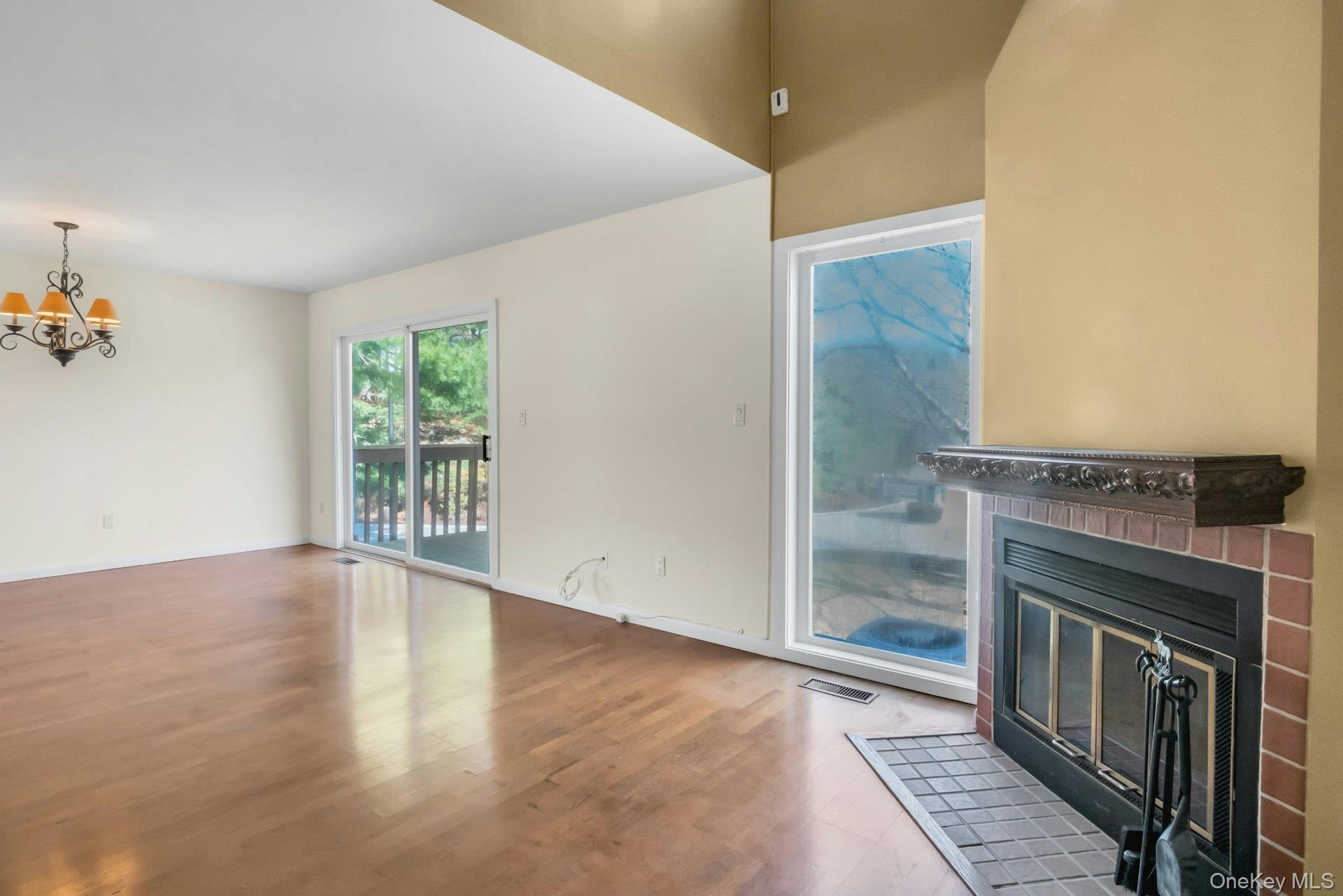 1 Spring Pond Drive, Unit 1 Ossining, NY 10562 - Photo 14 of 34 an empty room with wooden floor fireplace and windows