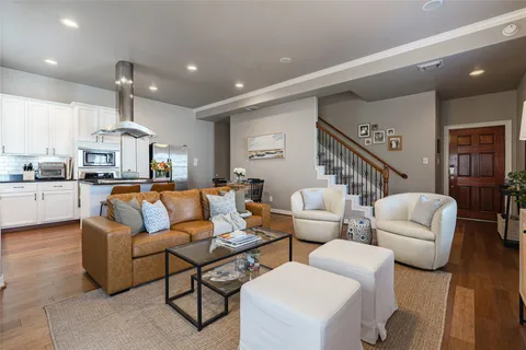 a living room with furniture kitchen view and a chandelier