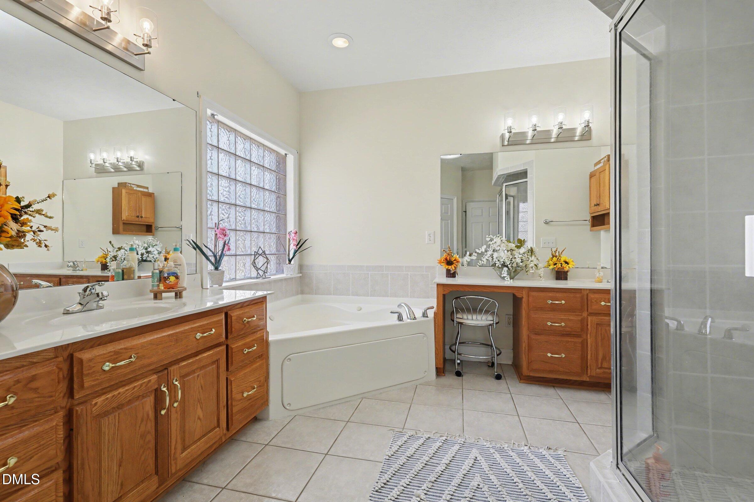 430 Fred Hall Road Stedman, NC 28391 - Photo 22 of 63 a spacious bathroom with a double vanity sink a mirror and a bathtub