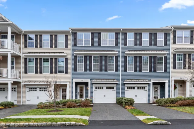 a front view of a building with a garden and plants
