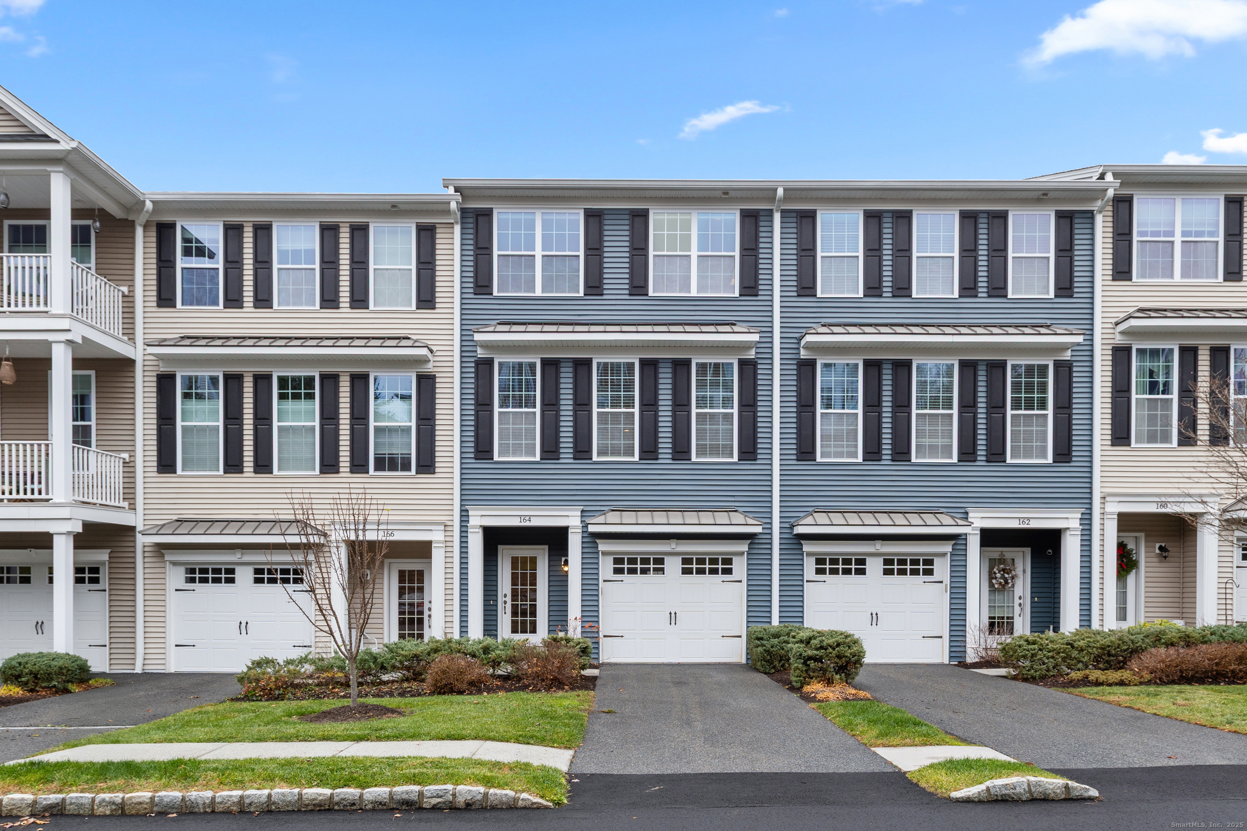 a front view of a building with a garden and plants