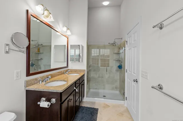 a bathroom with a sink a toilet and shower