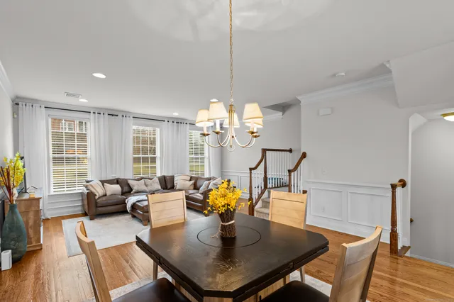 a view of a dining room with furniture a chandelier and wooden floor