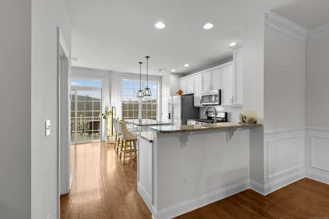 a kitchen with stainless steel appliances a table and chairs