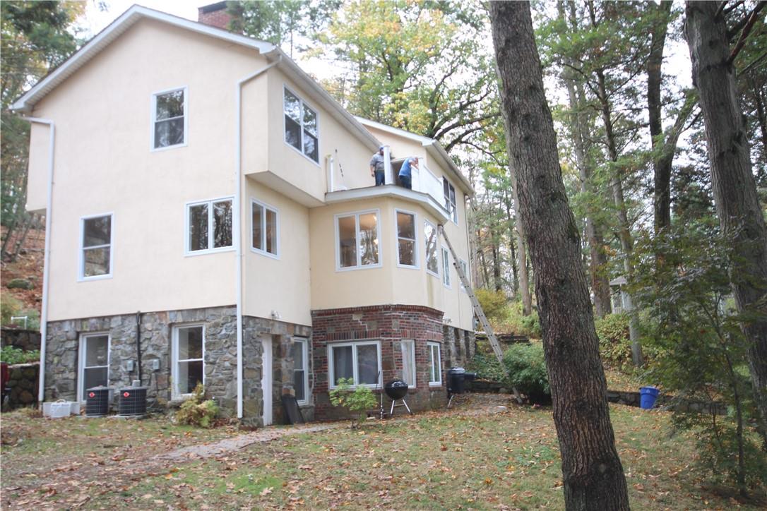 a view of a house with backyard and trees