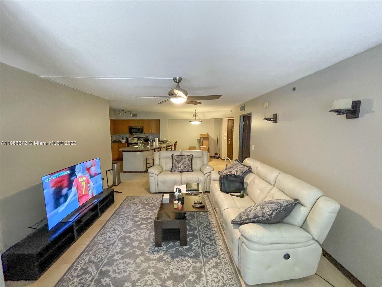 3153 Clint Moore Road, Unit 106 Boca Raton, FL 33496 - Photo 11 of 38 a living room with furniture and a flat screen tv