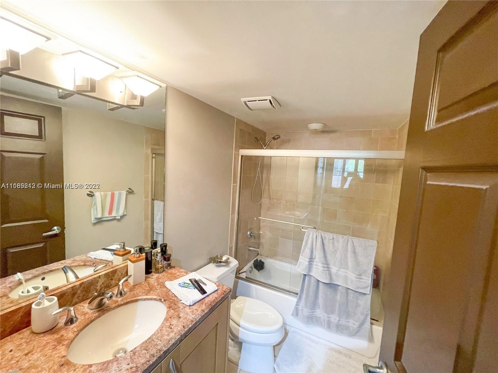 3153 Clint Moore Road, Unit 106 Boca Raton, FL 33496 - Photo 17 of 38 a bathroom with a granite countertop sink toilet a mirror and shower