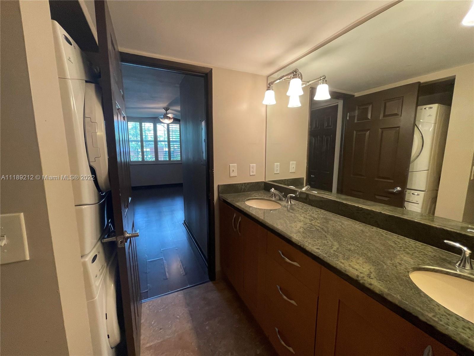3153 Clint Moore Road, Unit 106 Boca Raton, FL 33496 - Photo 38 of 38 a bathroom with a double vanity sink a toilet and a mirror