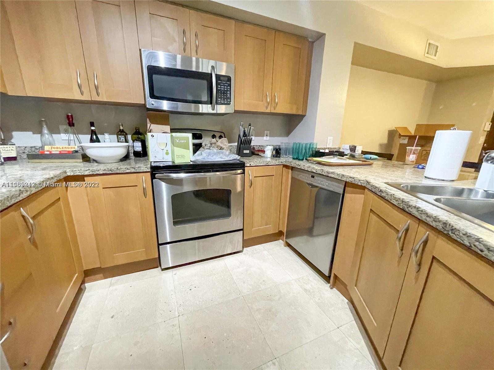 3153 Clint Moore Road, Unit 106 Boca Raton, FL 33496 - Photo 4 of 38 a kitchen with stainless steel appliances granite countertop a sink stove and microwave