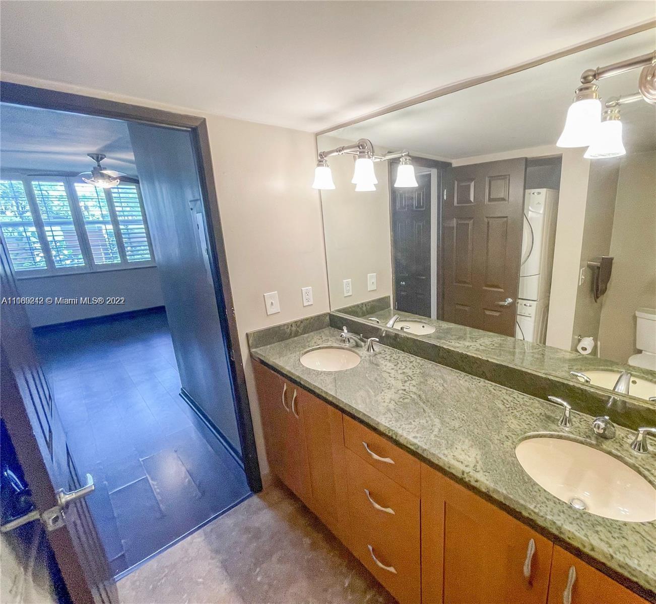 3153 Clint Moore Road, Unit 106 Boca Raton, FL 33496 - Photo 6 of 38 a bathroom with a granite countertop sink a mirror and a shower