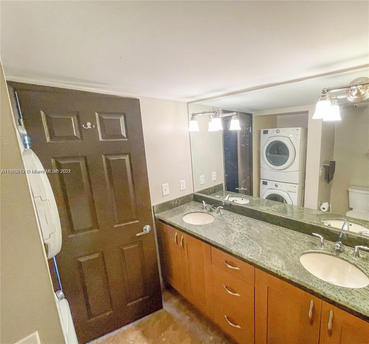 3153 Clint Moore Road, Unit 106 Boca Raton, FL 33496 - Photo 7 of 38 a bathroom with a granite countertop double vanity sink and mirror
