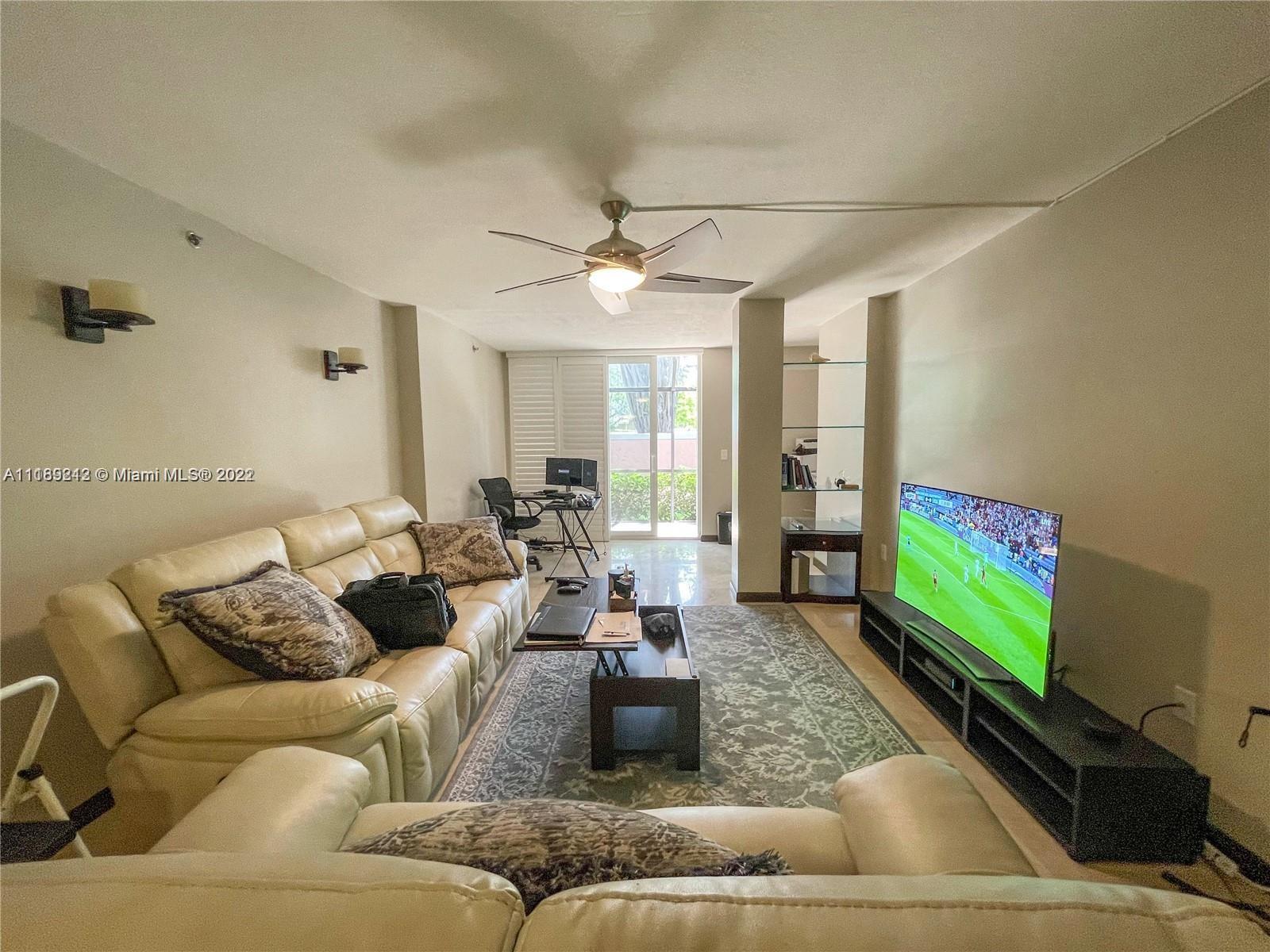 3153 Clint Moore Road, Unit 106 Boca Raton, FL 33496 - Photo 8 of 38 a living room with furniture and a flat screen tv