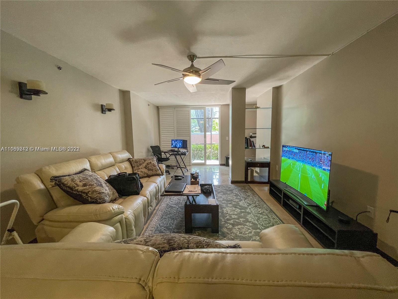3153 Clint Moore Road, Unit 106 Boca Raton, FL 33496 - Photo 9 of 38 a living room with furniture and a flat screen tv