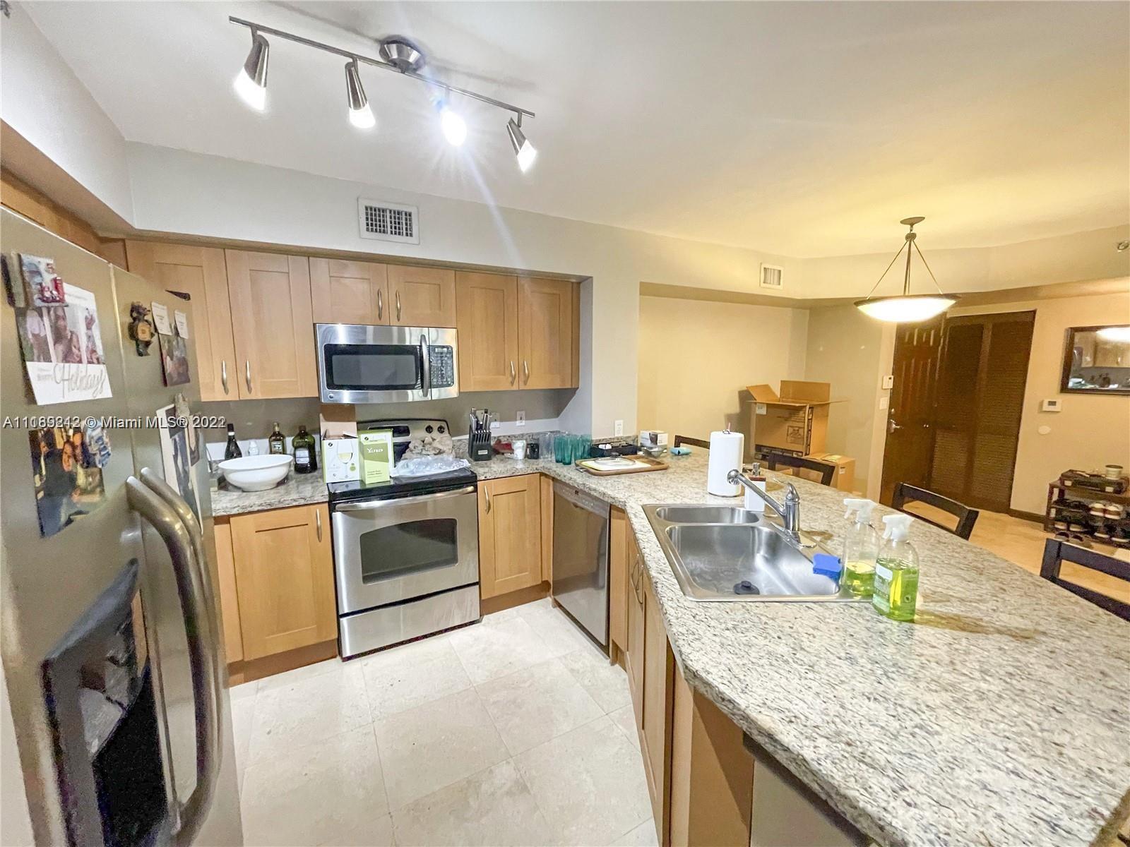 3153 Clint Moore Road, Unit 106 Boca Raton, FL 33496 - Photo 10 of 38 a kitchen with a sink stove and refrigerator