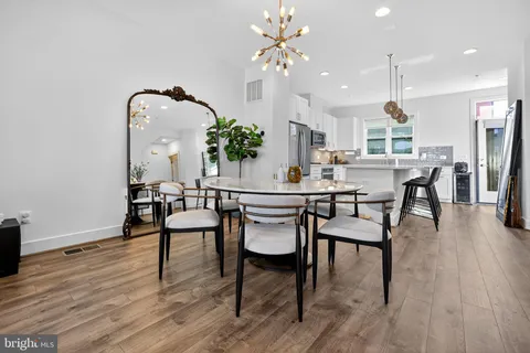 a dining room with furniture a chandelier and wooden floor