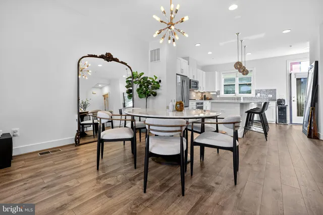 a dining room with furniture a chandelier and wooden floor