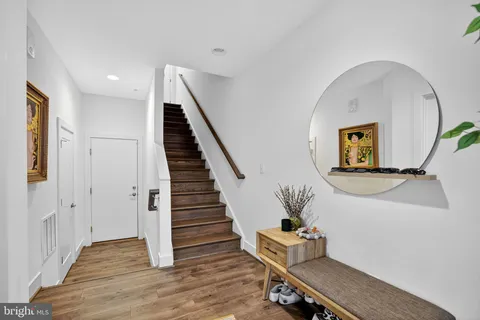 a hallway with wooden floor and stairs