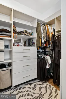 a view of walk in closet with clothes and shoes