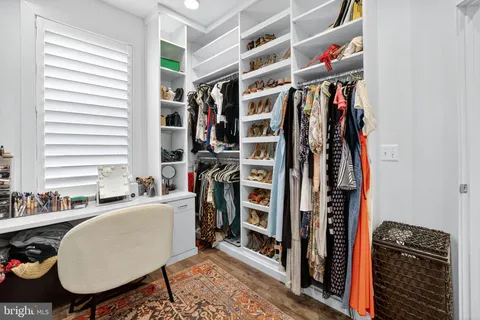 a view of walk in closet with clothes and shoes