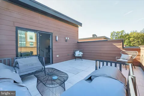 a view of a patio with couches table and chairs and potted plants